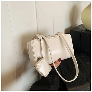 Detail of creamy white faux leather shoulder bag with matching mini coin purse attachment