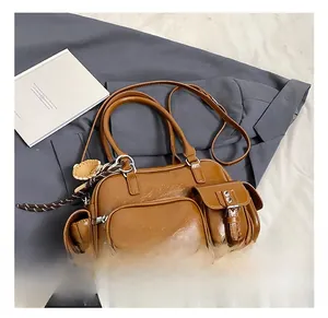 Detail showing multi-pocket brown tote bag with metal zippers and cute bear charm