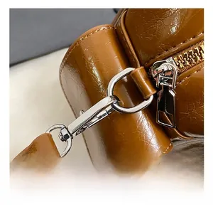 Detail of oil wax leather bag featuring vintage metallic side hooks and silver zipper