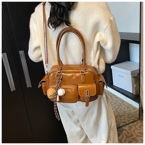 Close-up of vintage brown glossy tote bag with functional pockets and baseball charm