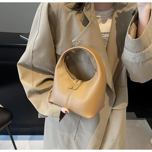 Detail of camel leather handbag with smooth matte texture and double zipper closure