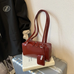Minimalist burgundy patent leather tote bag with matching mini pouch and long shoulder straps