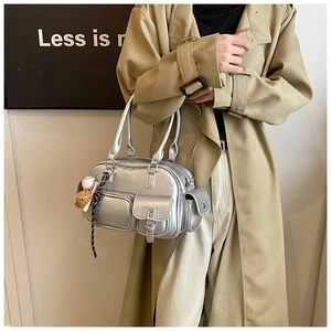 Detail of silver metallic bowling bag with dual handles and baseball charm accessory