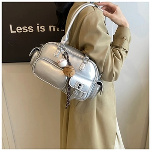 Detail of silver metallic handbag with multi-pocket design and baseball charm