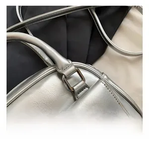 Detailed close-up of metallic silver Boston bag leather texture and premium hardware joints