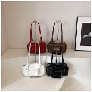 Minimalist display of vintage glossy leather shoulder bags in four colors on stands
