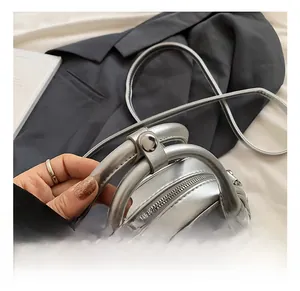 Close-up of silver metallic Boston bag featuring dual round handles and zip closure