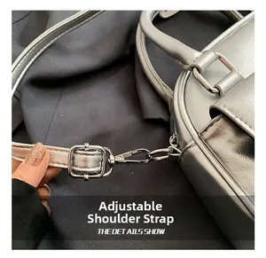 Close-up of adjustable silver shoulder strap with polished metallic buckle on Boston bag