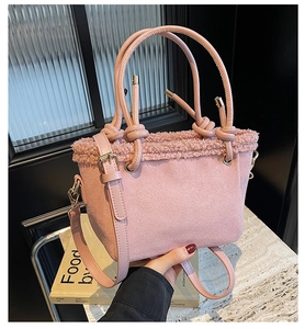 Detail view of pink faux suede bucket bag with soft fleece trim and knot strap handle