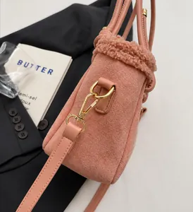 Détail du sac seau en daim rose avec bordure en peau lainée et fermoir doré