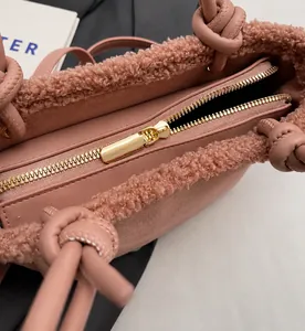 Détail du sac cabas en peluche rose montrant la fermeture éclair dorée et la poignée