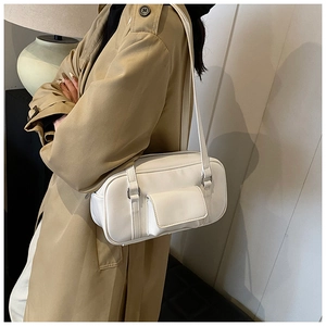 Close-up of white minimalist shoulder bag with rectangular front pocket and silver hardware