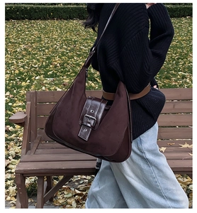 Detailed view of the dark brown vintage suede tote with decorative silver metal buckle