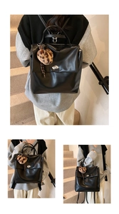 Detail eines schwarzen Rucksacks mit silbernem Drehverschluss und Leoparden-Bommel