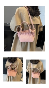 Detail of pink faux suede bucket bag with shearling trim and decorative knot handle