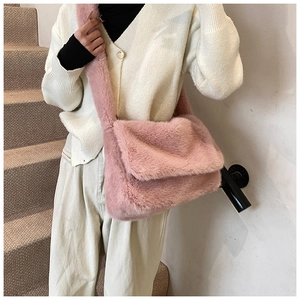 Detail van roze crossbodytas van imitatiebont met zachte pluche textuur en riem