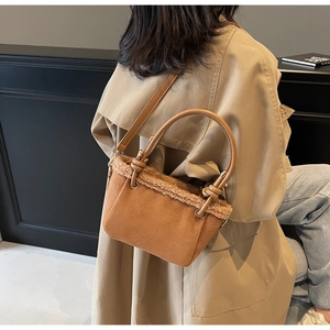 Detail of caramel suede bucket bag with shearling trim and stylish knotted handle