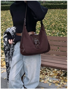 Detail der braunen Hobo-Tasche aus Canvas und Leder mit markanter dekorativer Gürtelschnalle
