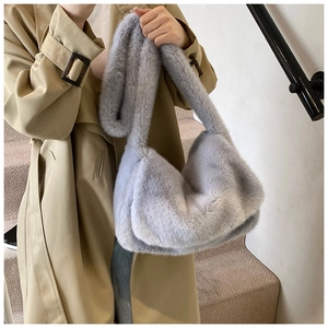 Detail van zachte lichtgrijze faux fur crossbody tas met pluizige textuur en riem