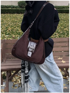 Close-up of vintage brown suede tote bag with leather trim and silver metal buckle