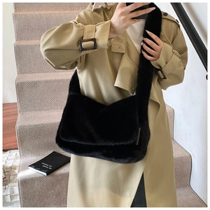 Detailopname van een zwarte crossbodytas van imitatiebont bij een kaki trenchcoat