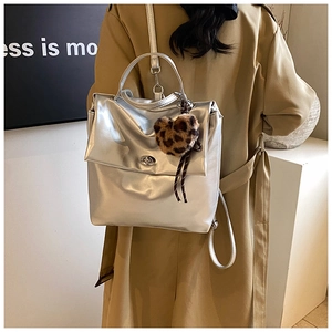 Rückansicht einer Frau mit silbernem Metallic-Rucksack und Leoparden-Herz-Anhänger