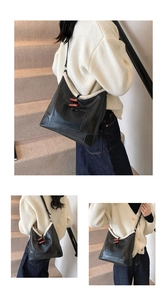 Detail of black leather tote bag with white faux fur trim and wooden olive button closure