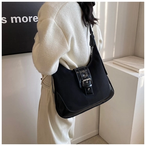 Close-up of black vintage tote bag with leather trim and silver metal buckle detail