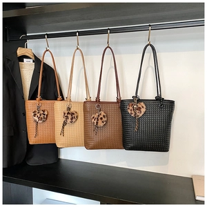 Close-up of woven texture on PU tote bags in four colors with leopard heart charms