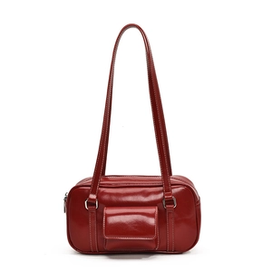 Deep red high-gloss leather shoulder bag with decorative front flap pocket on white background