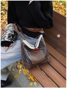 Detail of vintage coffee shoulder bag featuring white faux fur trim and horn button closure