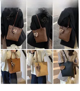 Detail showing woven texture of tote bags with a leopard print heart charm decoration