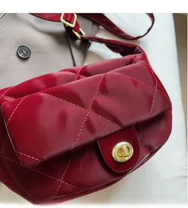 Close-up of deep red quilted patent leather handbag with a golden rotating clasp