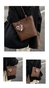 Detail of a dark brown woven tote bag with a leopard print plush heart charm detail