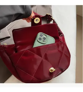 Interior view of burgundy quilted saddle bag with phone storage and gold hardware