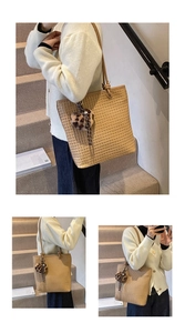 Detail of light brown woven tote bag featuring fine texture and leopard print pompom charm