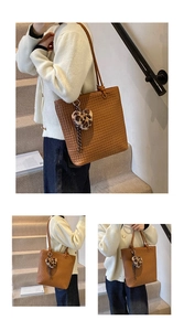 Detailed woven texture of brown tote bag with a leopard heart plush charm pendant