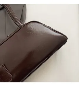 Detail of deep brown glossy leather bag showing soft texture and premium stitching