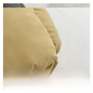 Gros plan sur la texture du tissu rembourré de ce sac à bandoulière en coton jaune clair
