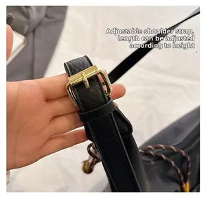 Détail de la bandoulière réglable en cuir noir avec boucle dorée pour sac à main