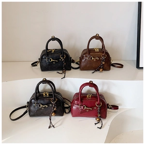 Detail view of retro Boston bags in four colors with leather texture and metal buckles