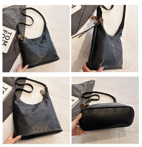 Vue détaillée du sac cabas en cuir PU noir avec breloque tennis et bandoulière chic