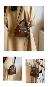Detail view of American vintage small Boston bag in dark brown with gold bell charm