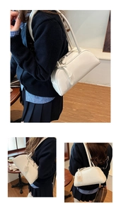 Detail of minimalist cream white Boston bag showing leather texture and double handles