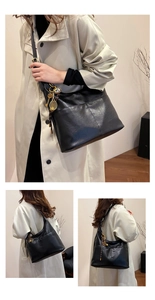 Détail du grand sac cabas noir avec breloque raquette de tennis et texture en cuir