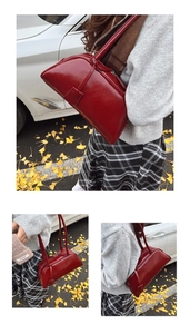Detail shot of a vintage deep red leather Boston shoulder bag with glossy finish and dual straps