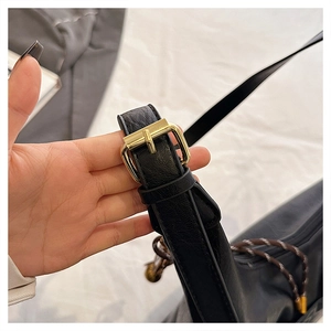 Close-up of black leather strap with gold adjustable metal buckle for tote bag