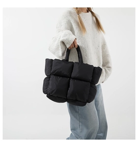 Détail du sac cabas matelassé noir montrant la texture bouffante et le tissu en nylon