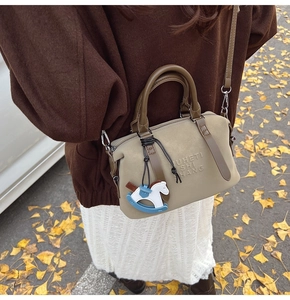 Dettaglio della borsa Boston kaki con ciondolo a cavallo e logo in rilievo