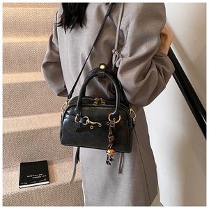 Classic black vintage Boston bag with gold horsebit buckle and stylish tassel on top